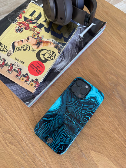 Blue and black marbled phone case on a wooden surface with a book and headphones.